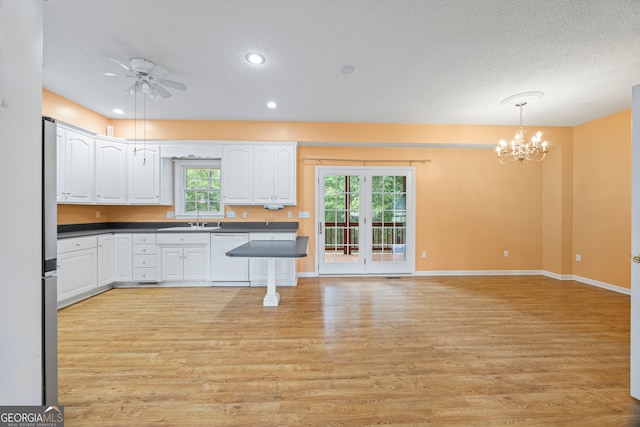 kitchen with light hardwood / wood-style floors, decorative light fixtures, dishwasher, and white cabinets