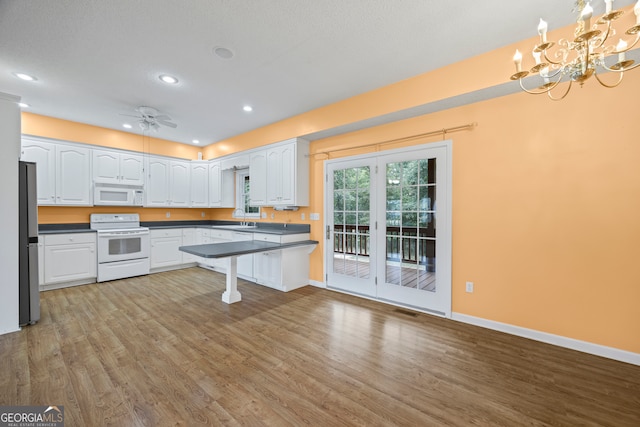 kitchen featuring light hardwood / wood-style flooring, white cabinets, white appliances, and pendant lighting