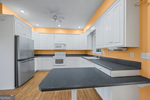 kitchen with light hardwood / wood-style floors, white cabinets, white appliances, ceiling fan, and sink