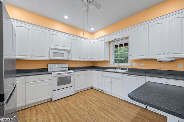 kitchen featuring ceiling fan, white cabinets, sink, white appliances, and light hardwood / wood-style flooring