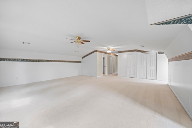 bonus room featuring lofted ceiling, ceiling fan, and light colored carpet