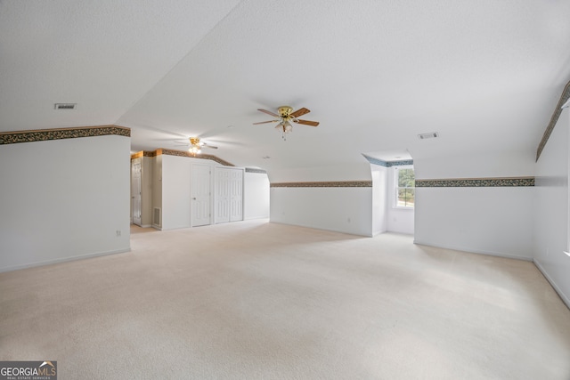 bonus room featuring ceiling fan, light colored carpet, and lofted ceiling