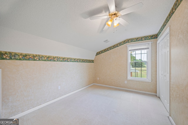 bonus room with ceiling fan, a textured ceiling, lofted ceiling, and light carpet