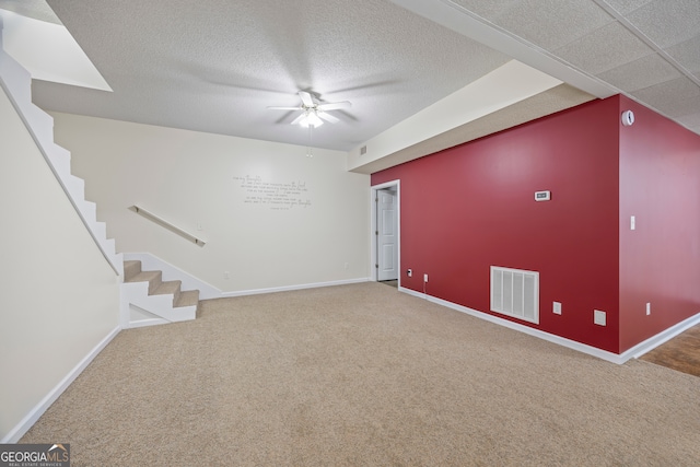 interior space with ceiling fan, a textured ceiling, and carpet flooring