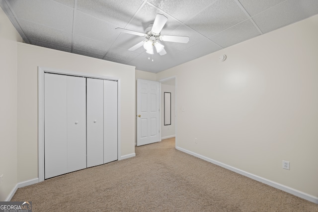 unfurnished bedroom with light carpet, a closet, and ceiling fan