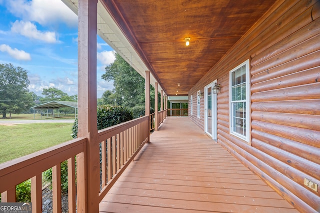 wooden terrace with a yard and covered porch