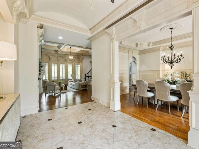 entryway featuring ornamental molding, beamed ceiling, coffered ceiling, and light hardwood / wood-style flooring