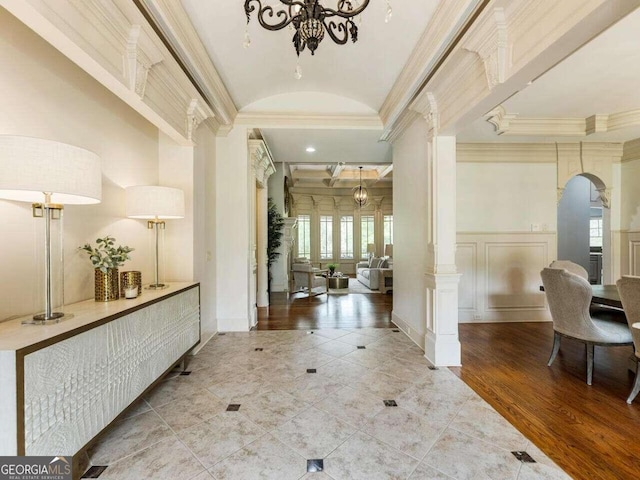 foyer entrance featuring ornate columns, ornamental molding, and hardwood / wood-style floors