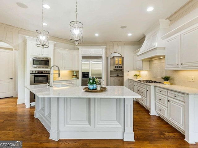 kitchen with a spacious island, built in appliances, and dark hardwood / wood-style floors