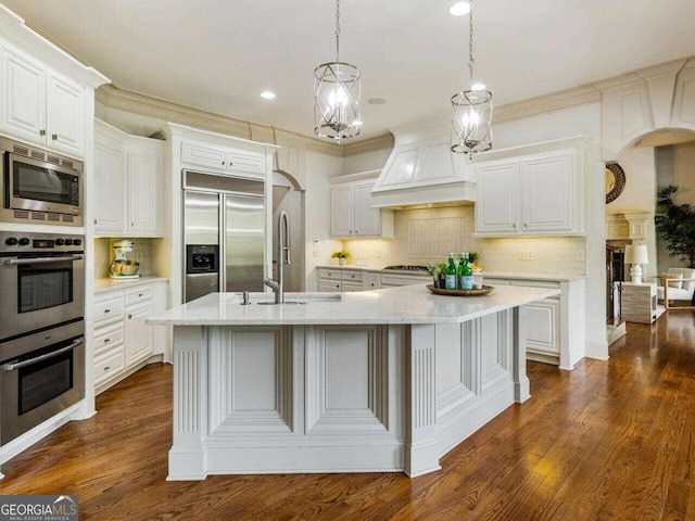 kitchen featuring white cabinets, built in appliances, dark hardwood / wood-style floors, and custom range hood