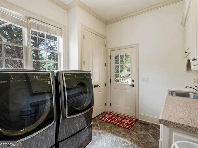 laundry room featuring washer and clothes dryer, cabinets, sink, and a wealth of natural light