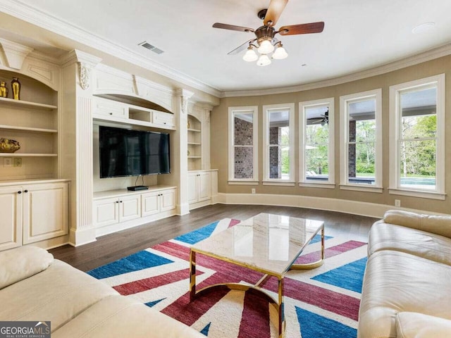 living room with built in features, crown molding, ceiling fan, and dark hardwood / wood-style flooring