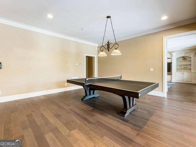 playroom featuring hardwood / wood-style flooring, built in features, and ornamental molding