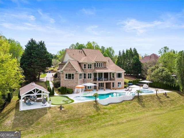 view of pool with a gazebo, a jacuzzi, a patio area, and a lawn