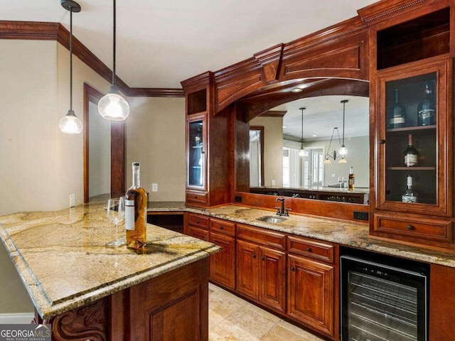 bar featuring hanging light fixtures, beverage cooler, sink, and light stone counters