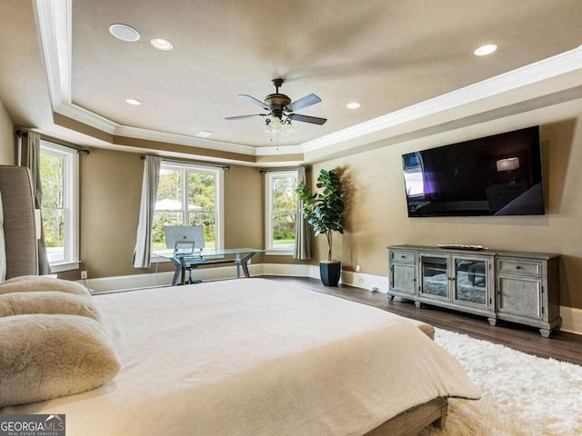 bedroom with crown molding, ceiling fan, hardwood / wood-style floors, and a raised ceiling