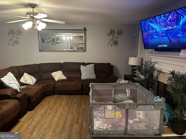 living room with ceiling fan and hardwood / wood-style floors