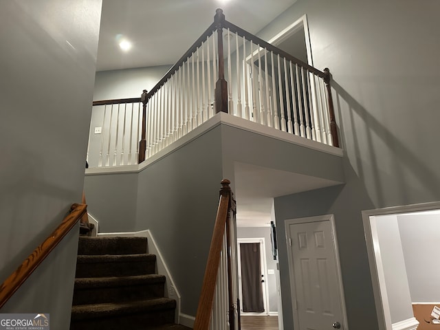 stairway featuring hardwood / wood-style floors and a towering ceiling