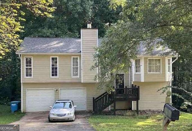 2734 Laurel View Dr, Snellville, GA 30039 - split foyer home featuring an attached garage, driveway, and a chimney