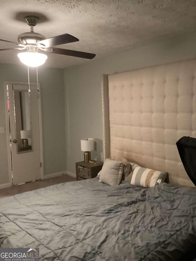 bedroom featuring ceiling fan and a textured ceiling