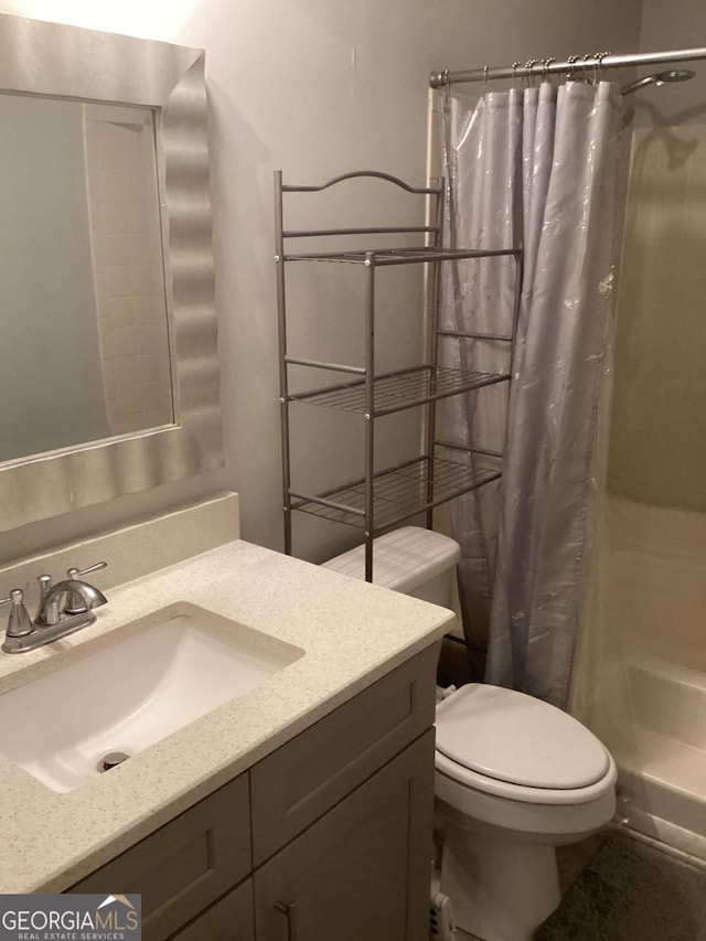 bathroom featuring vanity, curtained shower, and toilet