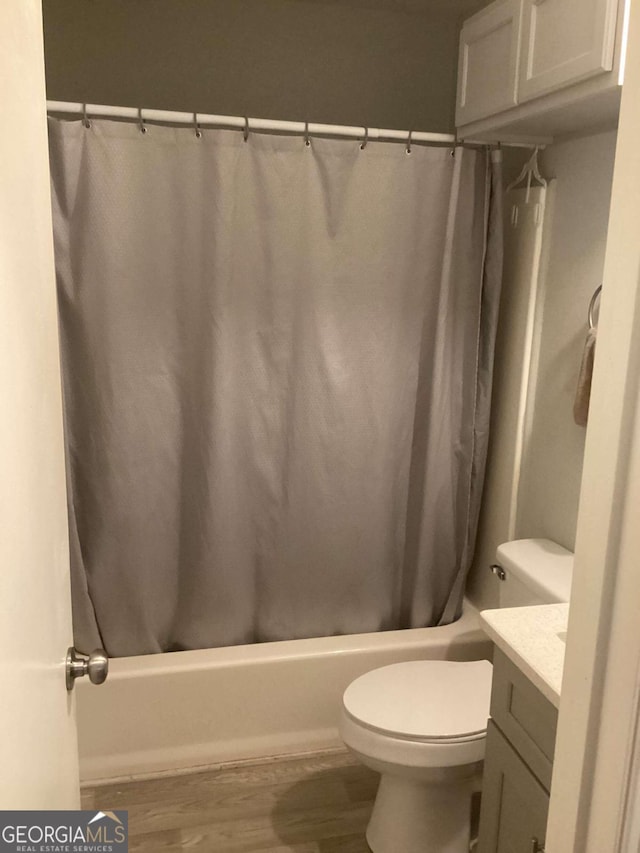 full bathroom with wood-type flooring, vanity, toilet, and shower / bathtub combination with curtain