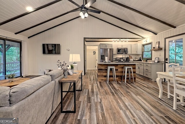 living room with a healthy amount of sunlight, beam ceiling, hardwood / wood-style floors, and sink