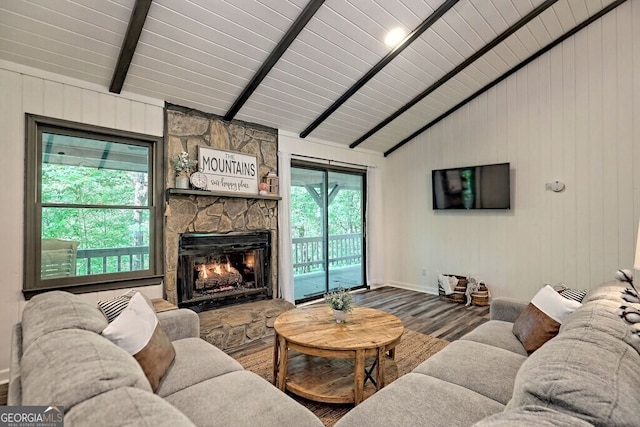 living room with a fireplace, hardwood / wood-style floors, vaulted ceiling with beams, and wooden walls