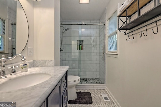 bathroom featuring tile patterned flooring, vanity, walk in shower, and toilet