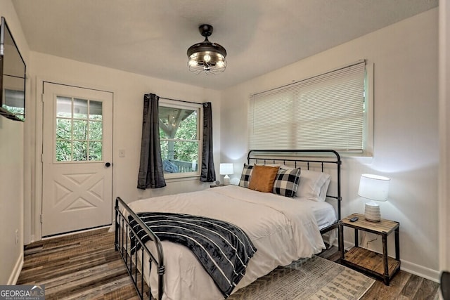 bedroom featuring dark hardwood / wood-style flooring and multiple windows