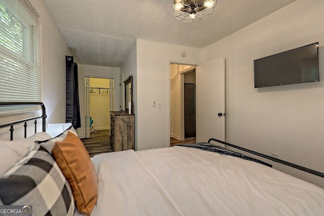 bedroom featuring a textured ceiling, a closet, and a walk in closet