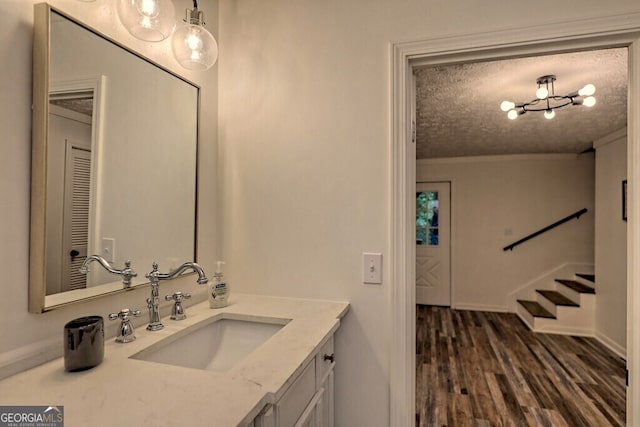 bathroom with vanity, wood-type flooring, and a textured ceiling