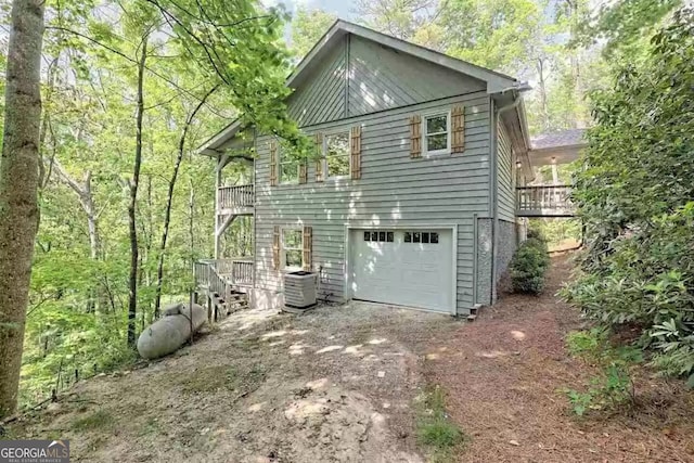 view of side of home featuring a deck, central AC unit, and a garage