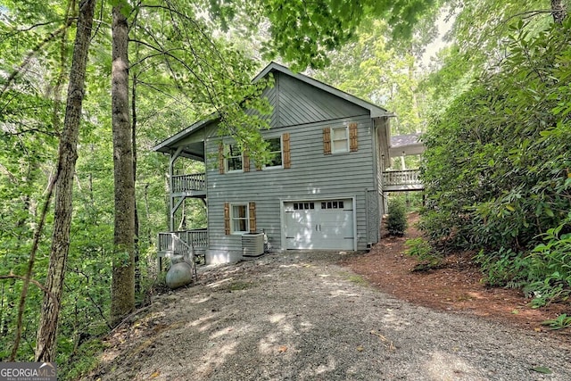 rear view of house featuring central AC, a balcony, and a garage