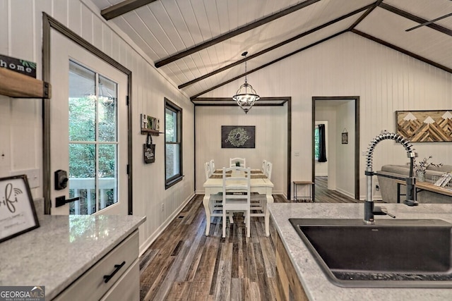 kitchen with pendant lighting, dark wood-type flooring, sink, and white cabinetry