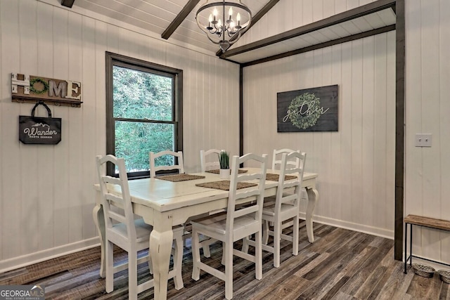 dining space featuring lofted ceiling, a notable chandelier, wood walls, and dark hardwood / wood-style floors