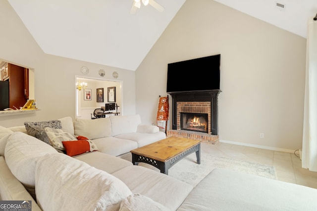 tiled living room with ceiling fan with notable chandelier, a fireplace, and high vaulted ceiling