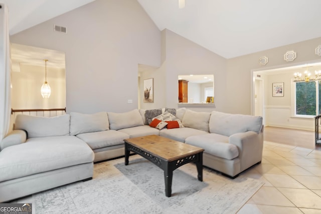 living room featuring light tile patterned floors, an inviting chandelier, and high vaulted ceiling