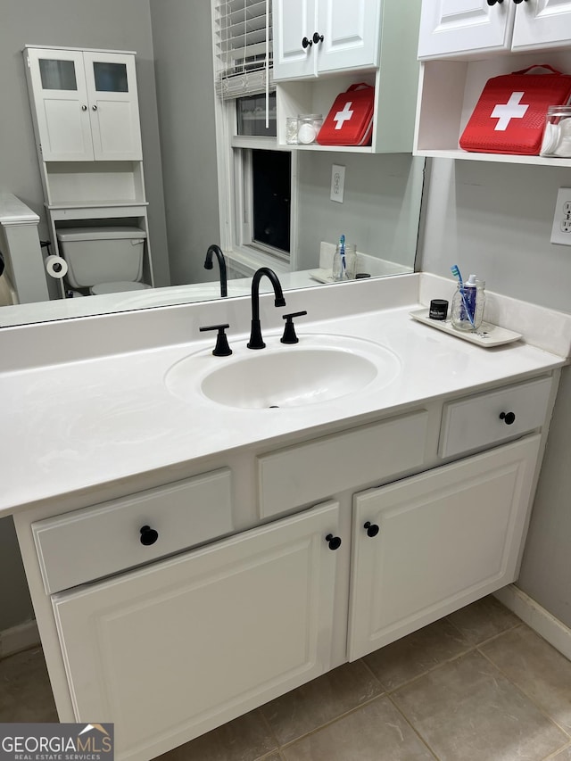 bathroom featuring tile patterned flooring, vanity, and toilet