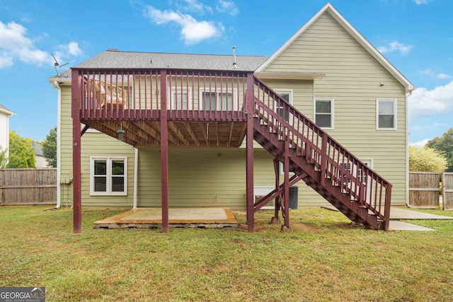 rear view of house featuring a deck and a lawn