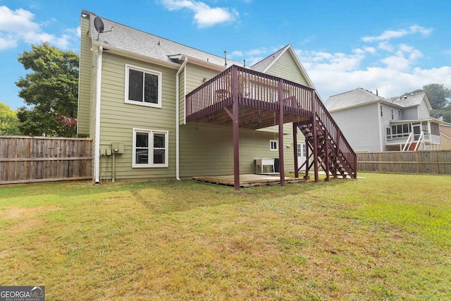 rear view of property featuring a lawn and a wooden deck