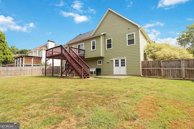 rear view of property with a yard, a patio area, and a wooden deck