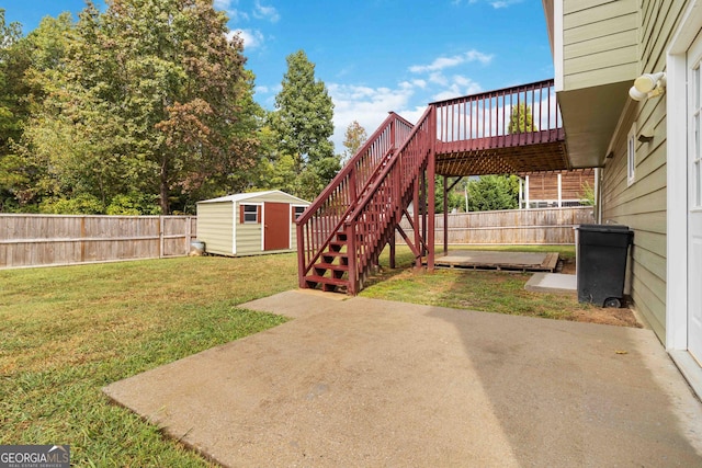 view of yard featuring a storage shed, a patio area, and a deck