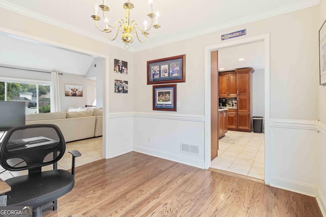 dining area with a notable chandelier, ornamental molding, and light hardwood / wood-style flooring