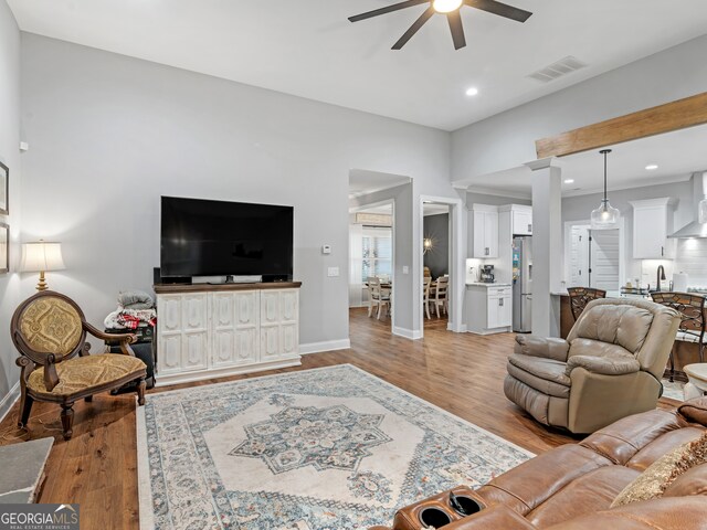 living room with light hardwood / wood-style floors and ceiling fan