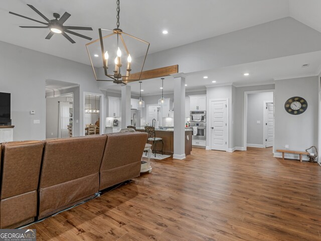 living room featuring ceiling fan with notable chandelier and light hardwood / wood-style flooring