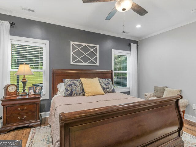 bedroom featuring light hardwood / wood-style floors, ceiling fan, and crown molding