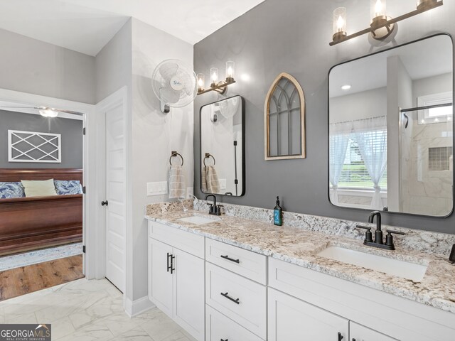 bathroom with a shower with shower door and vanity