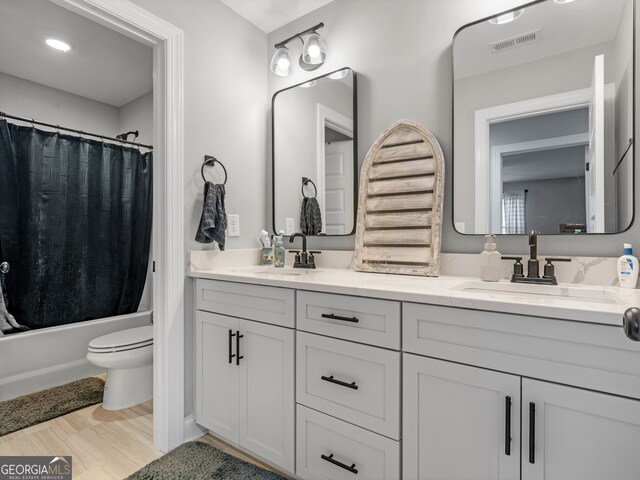 full bathroom with vanity, hardwood / wood-style floors, toilet, and shower / bathtub combination with curtain