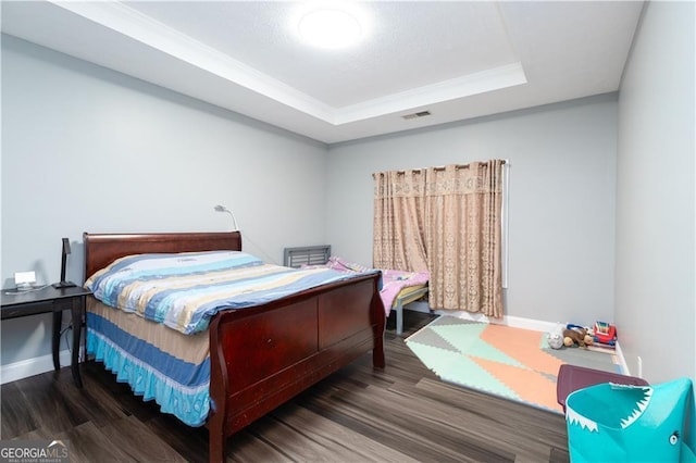 bedroom featuring a tray ceiling and dark hardwood / wood-style floors